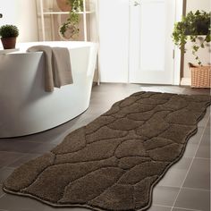 a bathroom with a bathtub and rug on the floor in front of a tub