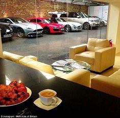 a room filled with lots of parked cars next to a coffee cup and saucer