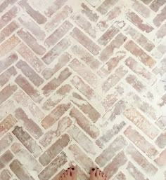 a person standing in front of a brick floor