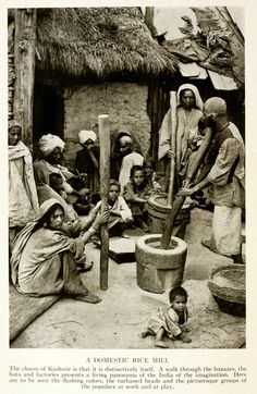 an old black and white photo of people in front of a hut with a baby sitting on the floor