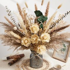 a vase filled with flowers sitting on top of a table next to a coffee cup