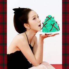 a woman holding a cake in front of her face