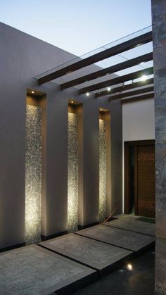 an outdoor area with lights and water features on the walls, along with concrete steps