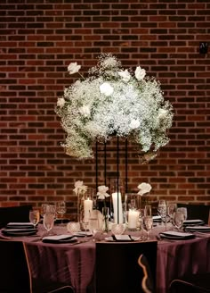 the table is set with white flowers and candles