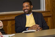 two men sitting at a table smiling for the camera