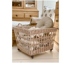 a wicker basket sitting on the floor next to a chair and dresser in a living room