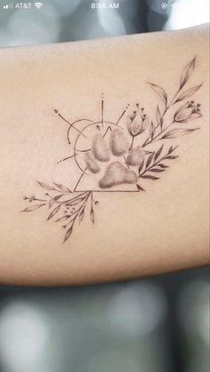 a woman's arm with a tattoo on it that has flowers and leaves in the center