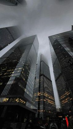 some very tall buildings under a cloudy sky