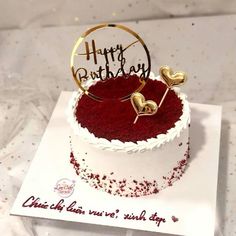 a red velvet cake with white frosting and gold decorations