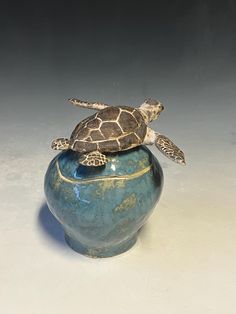 a turtle is sitting on top of a vase