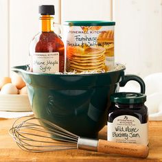 an assortment of condiments in a green bowl on a wooden table with eggs