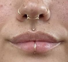 a woman's nose with two piercings on her nose and one in the middle