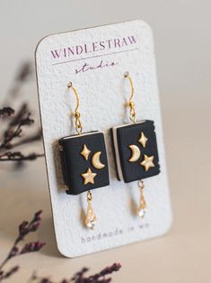 a pair of black and gold earrings with stars