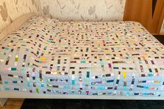 a bed that has been made with many different colored squares on the top and bottom