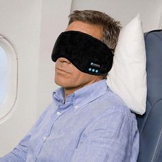 a man wearing a sleep mask on an airplane