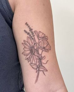 a woman's arm with a flower tattoo on the back of her left arm