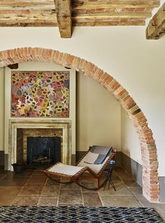 a living room with a fireplace and stone arches