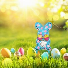 an image of easter eggs in the grass with bunny ears on them and other decorations