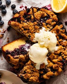 blueberry cobbler with ice cream on top and sliced lemons in the background