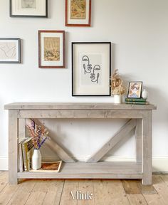 a wooden table with pictures on the wall above it