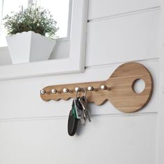 a wooden key holder hanging on the side of a door