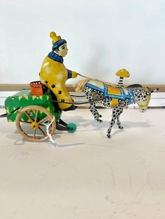 a ceramic figurine of a man on a horse pulling a cart with a dalmatian dog