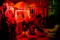 two clowns are sitting in the middle of a room with red lights on it