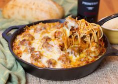 a skillet filled with spaghetti and meatballs