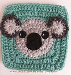 a crocheted koala bear is shown on top of a green square with black eyes