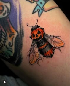 a close up of a tattoo with a bee on it