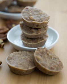 a stack of cookies sitting on top of a white plate next to pecans and nuts