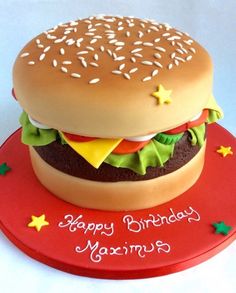 a birthday cake made to look like a hamburger on top of a red platter