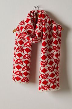 a red and white scarf hanging on a hook