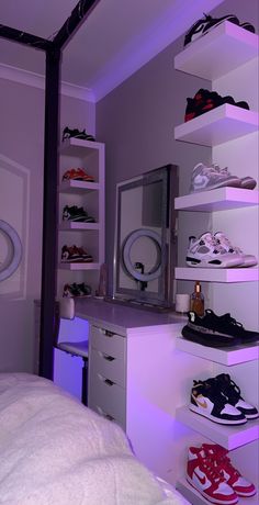 a bedroom with white shelves filled with shoes