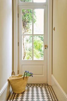 a basket sitting on the floor in front of a door with a window behind it