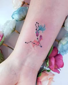 a woman's foot with a flower tattoo on her left ankle and pink flowers in the background