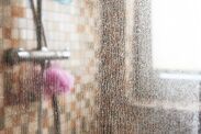 the shower head is covered with water droplets from the shower faucet, and it appears to be condensation