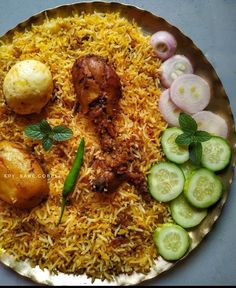 a plate filled with rice, cucumbers and meat