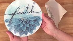 someone is holding up a plate with the word faith on it and flowers painted on it