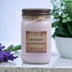 a pink candle sitting on top of a table next to a potted plant and some flowers