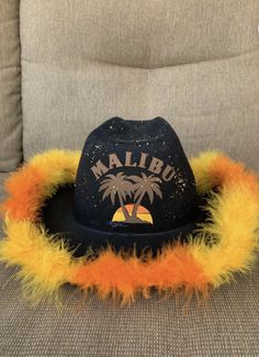 a hat that is sitting on top of a couch with fuzzy fur around the brim