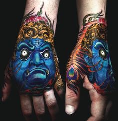 two hands that have tattoos on them and one has an image of a face painted on it