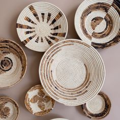 woven baskets are arranged on the wall in different sizes and shapes, including one with an oval design