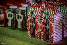 coca - cola bottles wrapped in red and green paper are sitting next to each other on a table