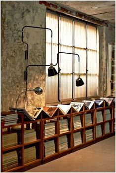 an empty room with many bookshelves and lamps on the windows sills