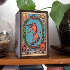 a wooden box sitting on top of a shelf next to a potted plant