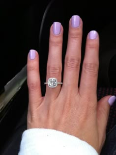 a woman's hand with a ring on top of her finger and purple nails