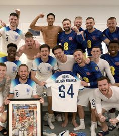 a group of men posing for a photo with a soccer jersey and an award plaque