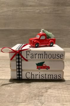 a stack of books with a red truck and christmas tree on top