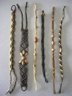 five different types of beaded bracelets on a white surface